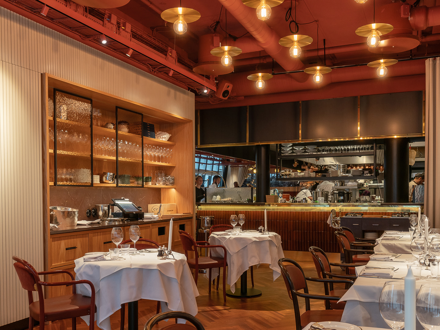 Sala restauracyjna Brasserie Astoria z barem, drewnianą boazerią i nakrytymi stolikami, nagłośniona systemem Genelec Smart IP
